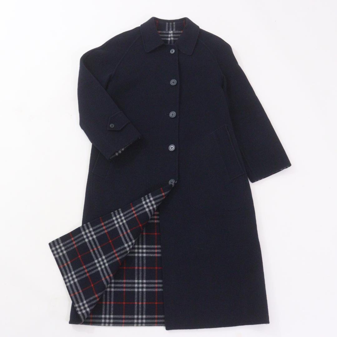 Navy Burberrys men's long wool coat laid flat showing the front with part of the Nova check lining revealed.