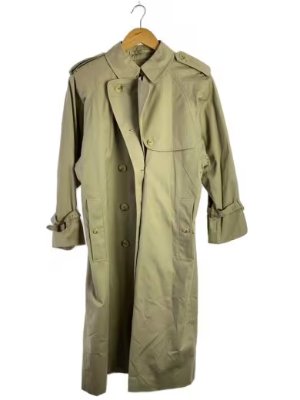 Beige BURBERRYS cotton women's trench coat hanging on a wooden hanger against a plain background.