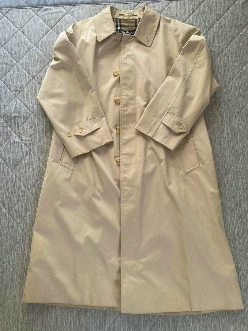 Beige men's coat laid flat showing the front, collar, buttons, and sleeves.
