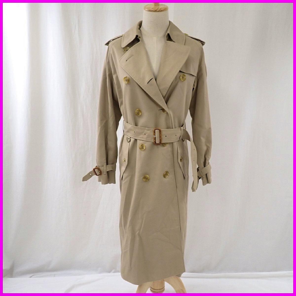 Beige Burberry trench coat displayed on a mannequin, double-breasted with belt and epaulets.