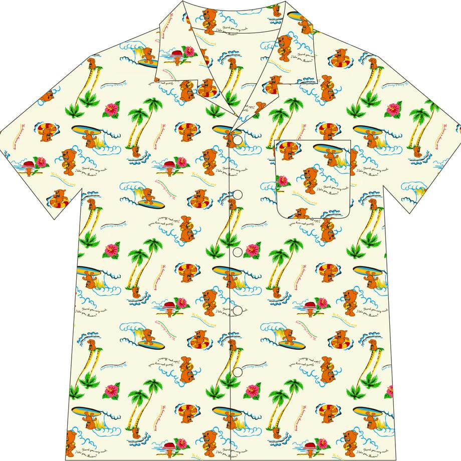 Front view of a men's Aloha shirt showing a cream background with repeating Buster-Kun cartoon surfing and palm tree print, short sleeves, a chest pocket, collar, and button front.