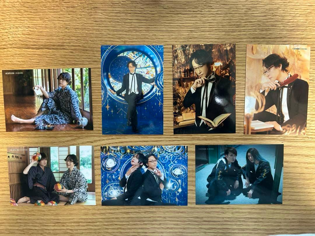 Eight 執事歌劇団 伊織 ブロマイド photos arranged on a wooden surface.