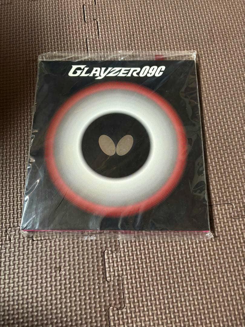 Sealed front-side packaging of a Butterfly GLAYZER 09C table tennis rubber showing the circular design and logo.