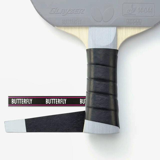 Table tennis racket handle wrapped with black Butterfly soft grip polyurethane tape, with a separate branded tape strip shown beside it.