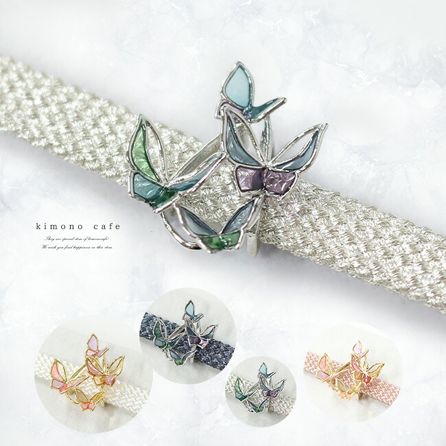 Close-up of a woven kimono obijime (obi cord) featuring a silver butterfly decorative clasp with colored enamel.