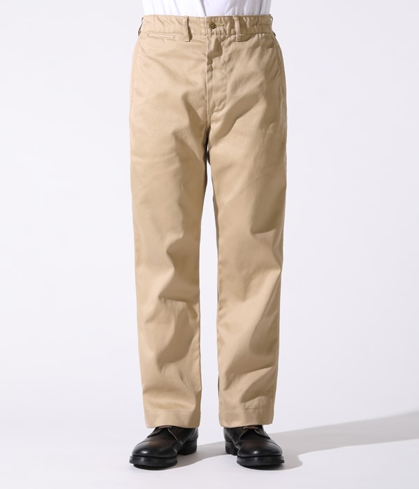 Front view of beige men's chinos worn by a model from the waist to the shoes against a white background.