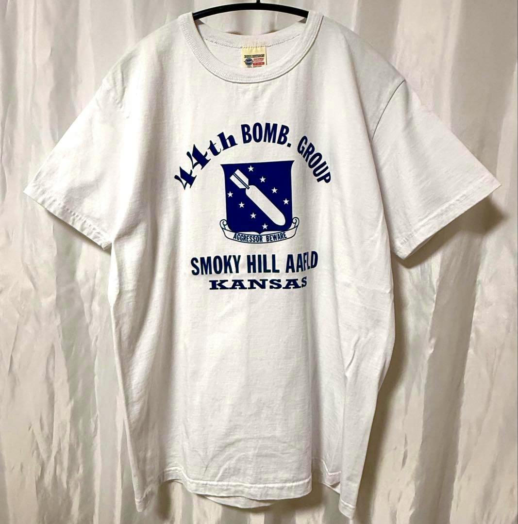 White Buzz Rickson T-shirt with blue 44th Bomb Group "Smoky Hill AAFld Kansas" front graphic hanging on a hanger.