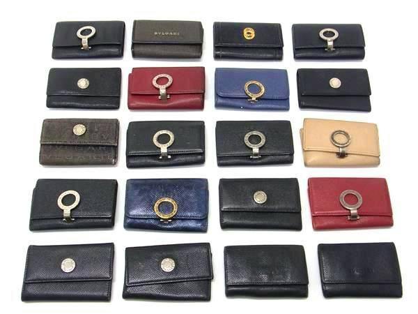 Twenty BVLGARI key cases and small wallets in various colors arranged in a grid on a white background.