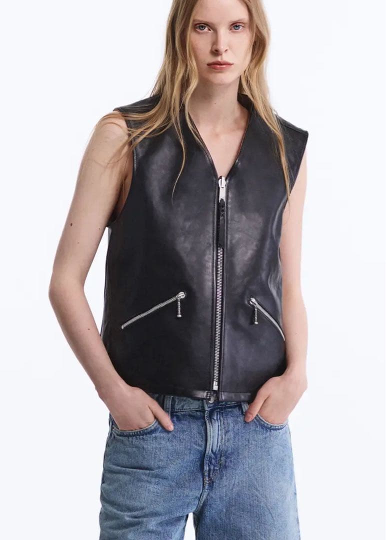 Model wearing a black BYREDO cow leather vest with a central zipper and two slanted zip pockets, front view.