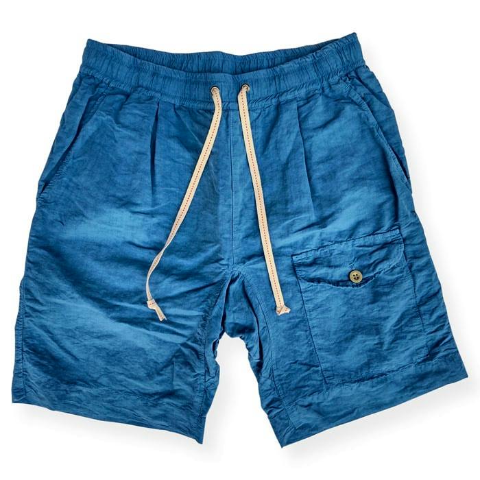 Blue men's cotton shorts laid flat with a drawstring waistband and a buttoned patch pocket.