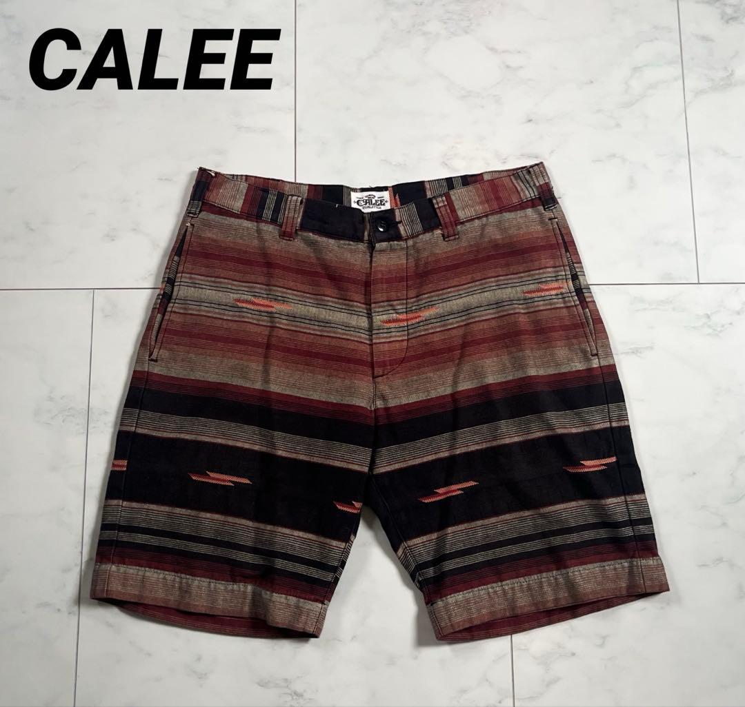 Polyester men's shorts with multicolored horizontal stripes laid flat on a white tiled floor.