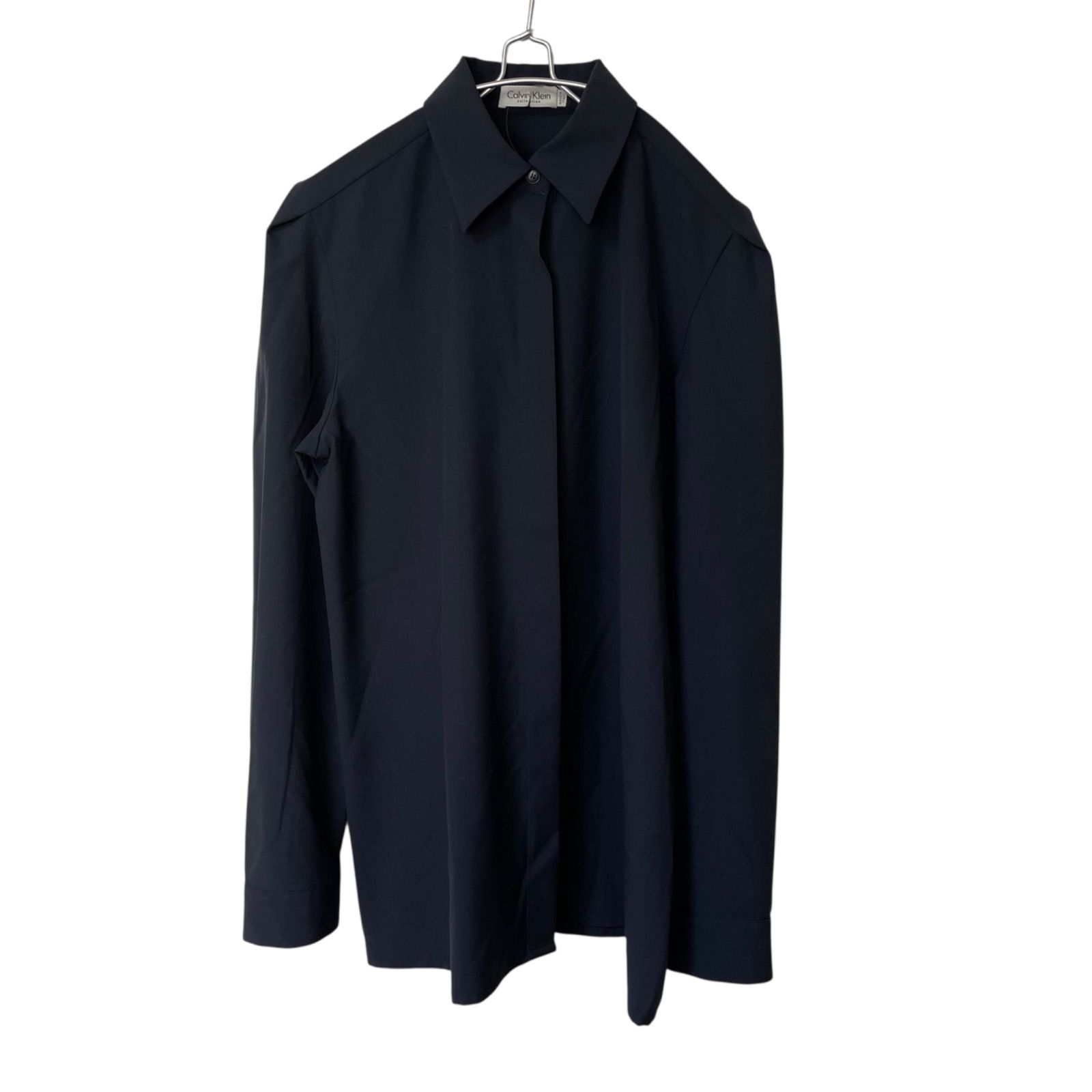 Navy concealed-button long-sleeve shirt on a hanger against a white background.
