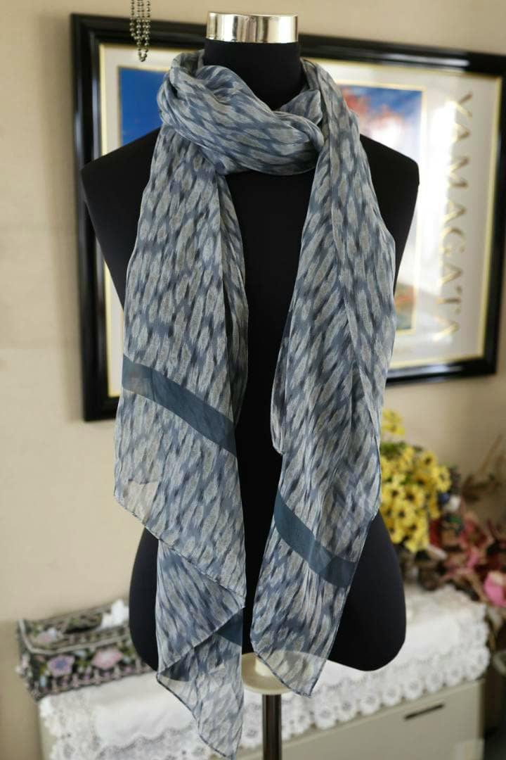 Calvin Klein blue patterned silk shawl draped on a black mannequin.