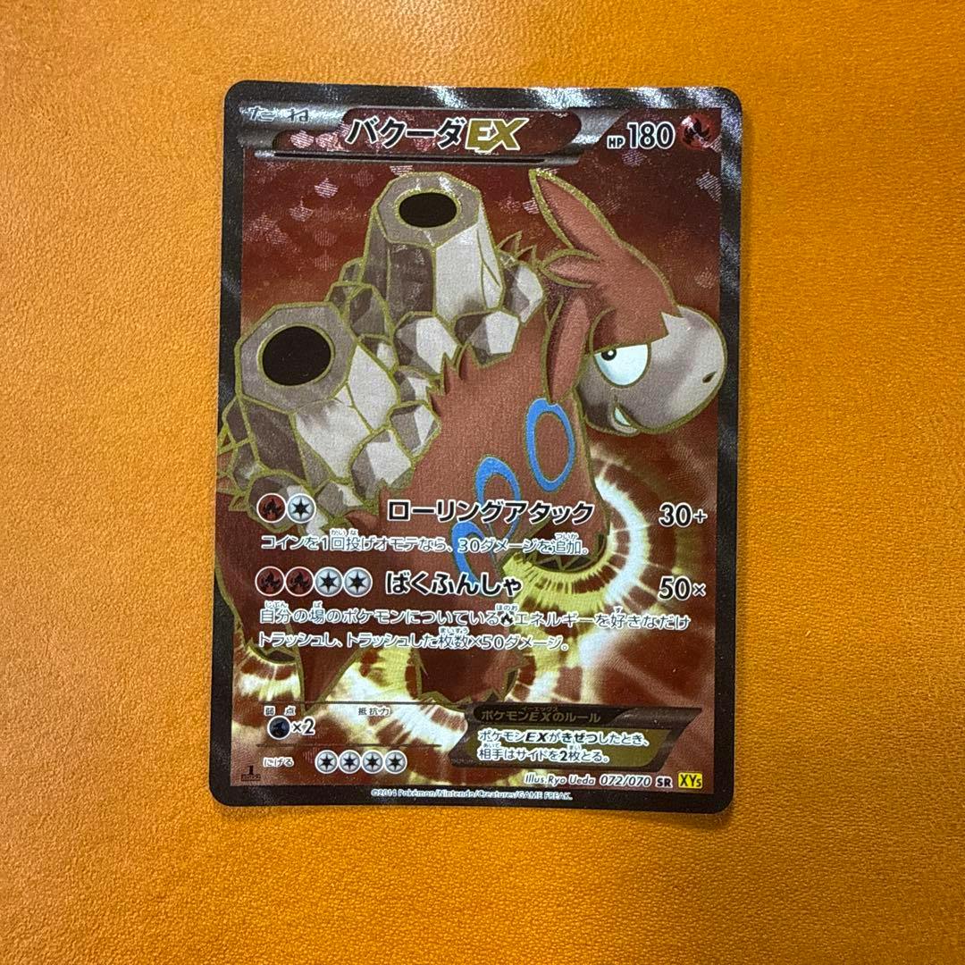 Photograph of the front of the バクーダEX SR trading card showing the card artwork, Japanese text, and stats.