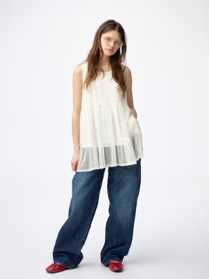 A model wearing the camisole tunic dress layered over jeans against a plain white background.