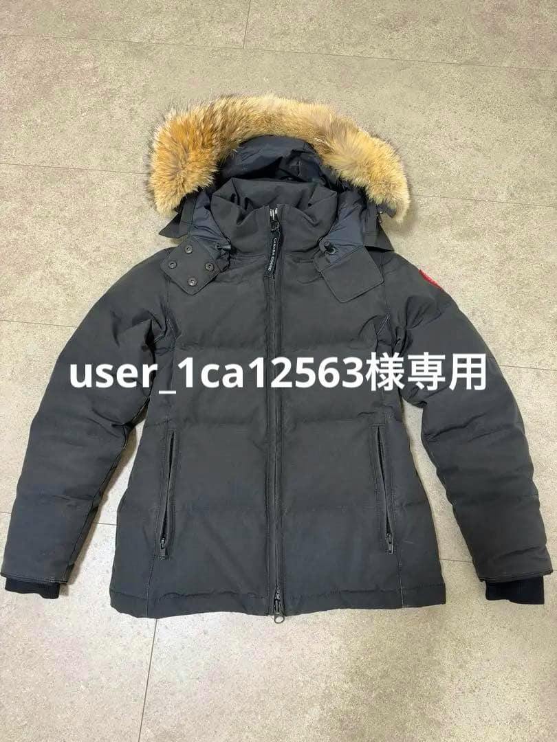 Front view of a Canada Goose down jacket (XS) with fur-trimmed hood laid flat, showing a white overlaid text across the chest.