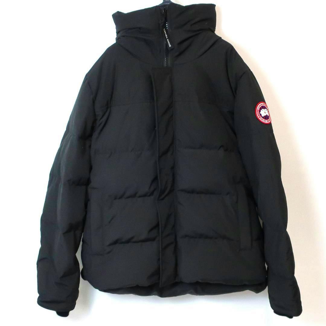 Front view of a black men's Canada Goose Macmillan parka down jacket hanging on a hanger with the sleeve logo visible.