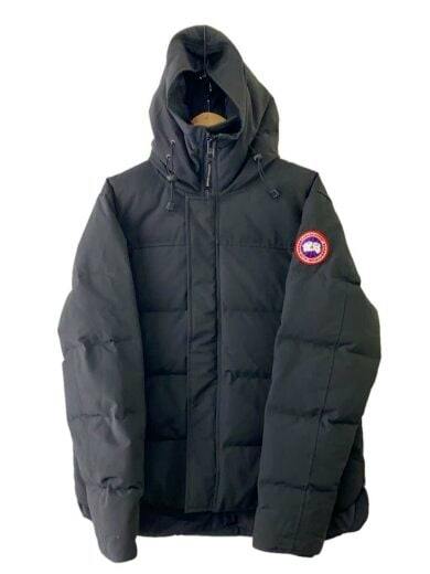 Front view of a black men's parka jacket with hood and a round logo patch on the left sleeve.