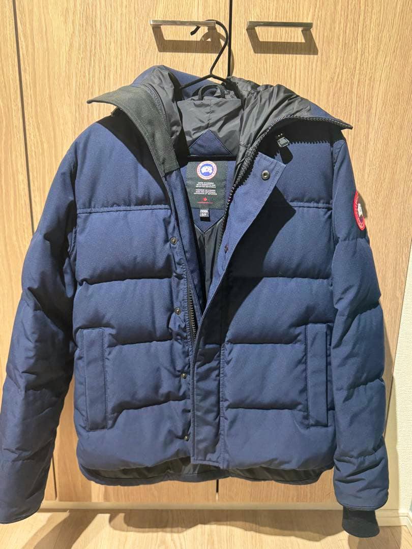 Front view of a navy Canada Goose Macmillan parka (men's jacket) hanging on a hanger.