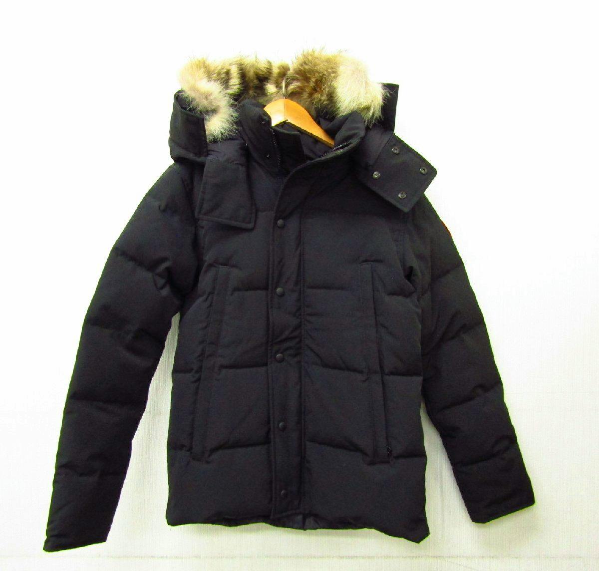Front view of the black CANADA GOOSE Wyndham Parka down jacket with fur-trimmed hood hanging on a hanger.