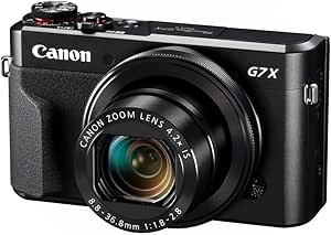 Black Canon PowerShot G7 X Mark II compact digital camera shown at an angle with its lens extended, showing front and top controls.