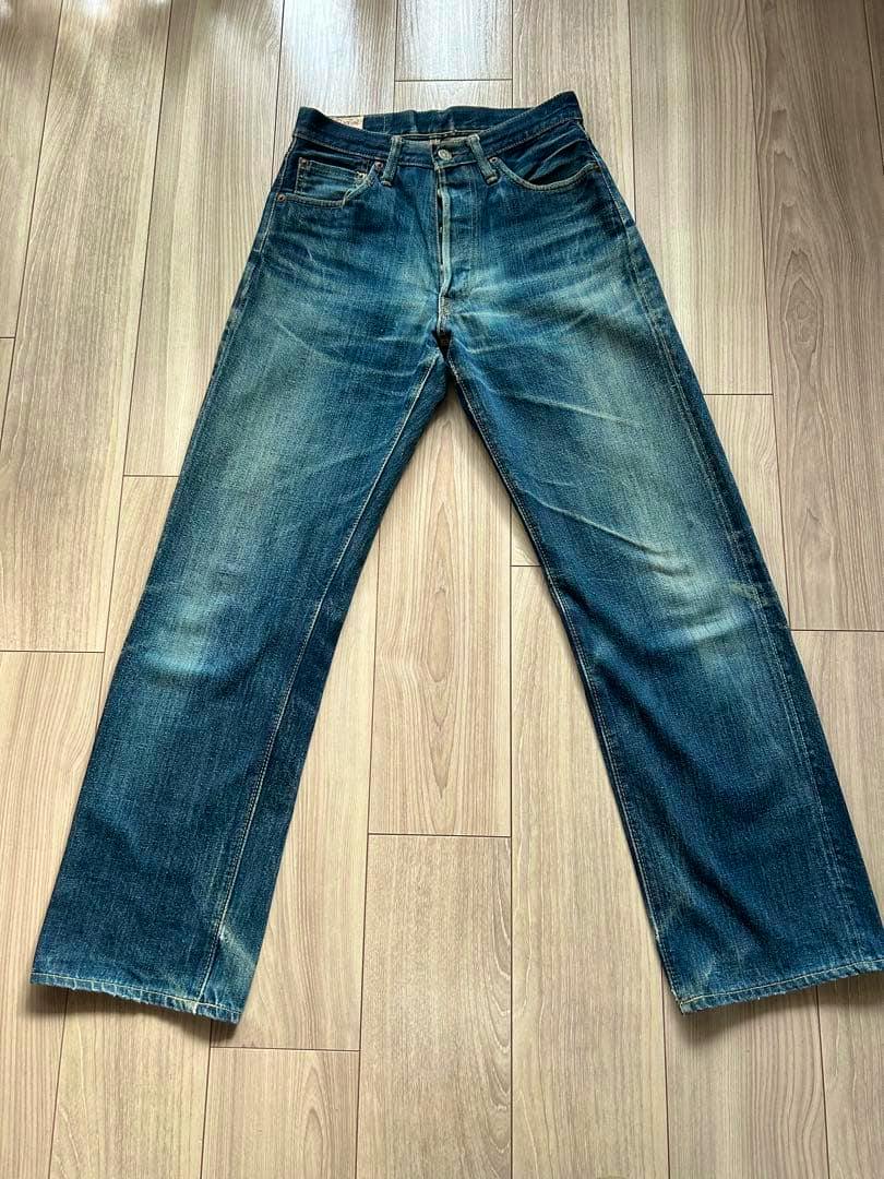 Front view of CANTON LOT 550 denim men's jeans laid flat on a wood floor showing faded wear.