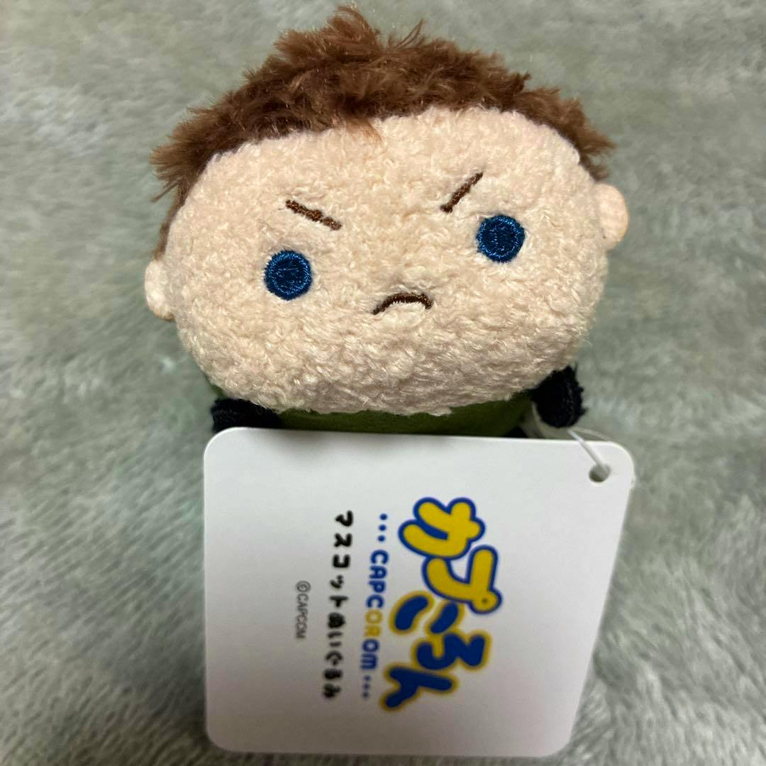 Front view of the Chris plush mascot showing its embroidered face and the attached product tag.