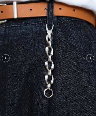 Silver metal carabiner key holder with linked oval rings hanging from a denim belt loop.