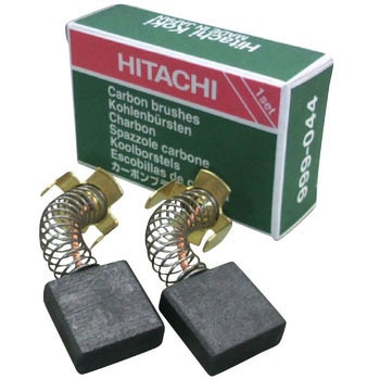 Two carbon brushes with attached springs displayed in front of a Hitachi product box.