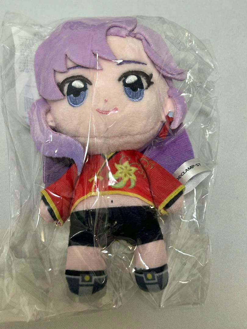 Packaged mascot plush (ヴァンガード カードゲーム祭2026 員弁ナオ) with purple hair wearing a red top and black shorts.
