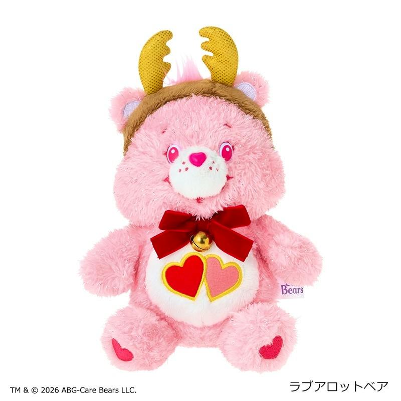 A pink Care Bears Christmas plush wearing a reindeer antler headband, a red bow with a bell, and heart symbols on its belly and feet.