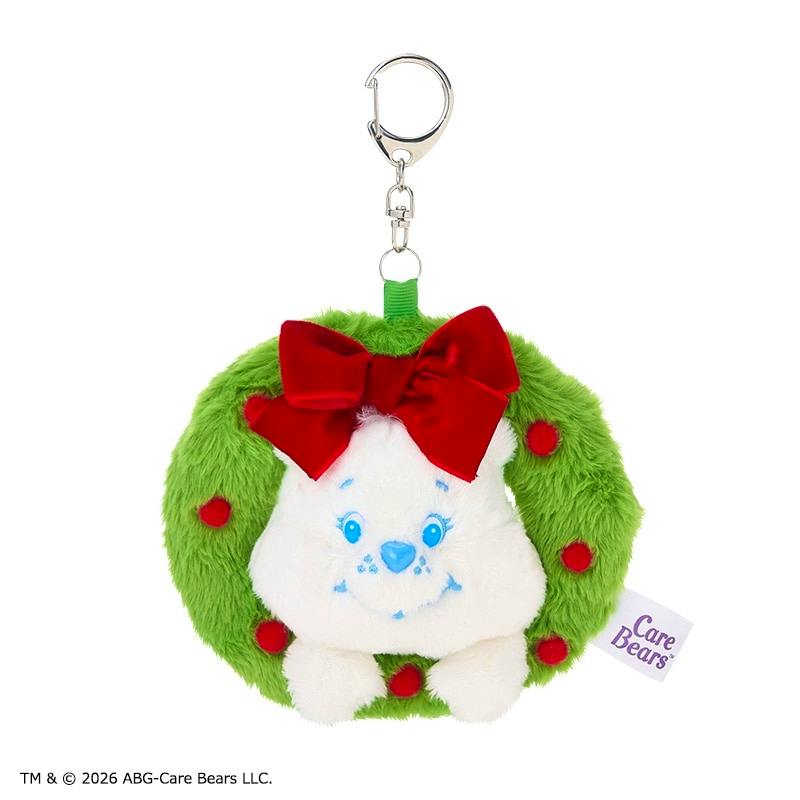 Front view of the Care Bears green plush wreath keyring showing a white bear face with blue features, a red bow and red pom-poms, and a metal key clip.