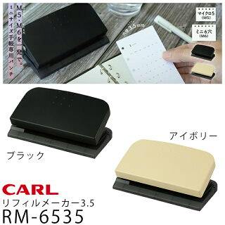 Photo showing the CARL RM-6535 3.5 hole punch in black and ivory, with one unit being used to punch a sheet of refill paper.