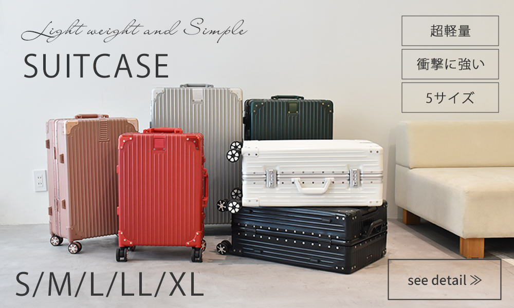 Several hard-shell suitcases in different colors displayed on the floor against a wall.