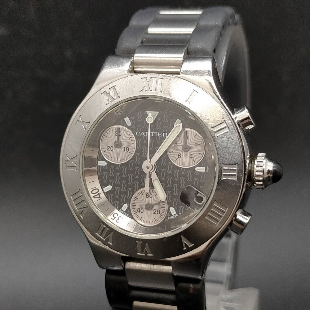 Front-facing photo of the Cartier wristwatch showing a Roman-numeral bezel, three chronograph subdials, a date window, and a metal bracelet.