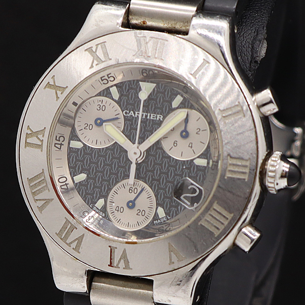 Close-up of a Cartier men's chronograph watch with a black patterned dial, three subdials, Roman numeral bezel, and leather strap.
