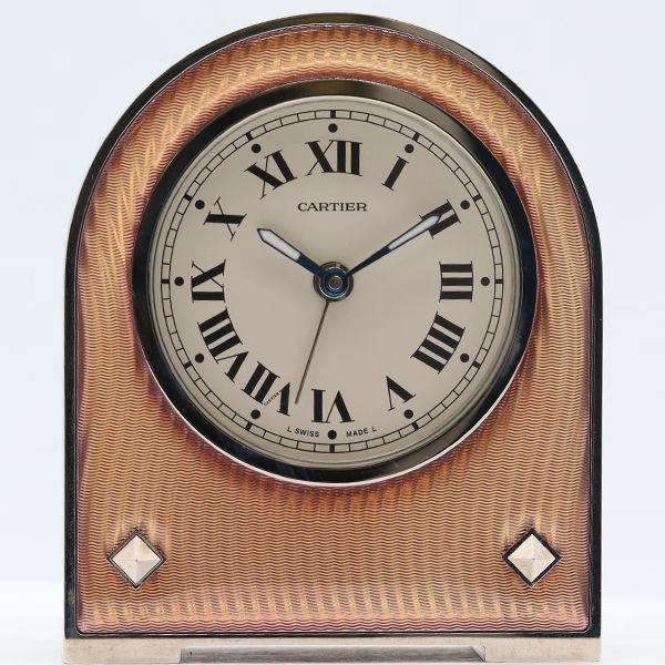 Front view of the Cartier desk clock with a white dial, Roman numerals, and decorative case.
