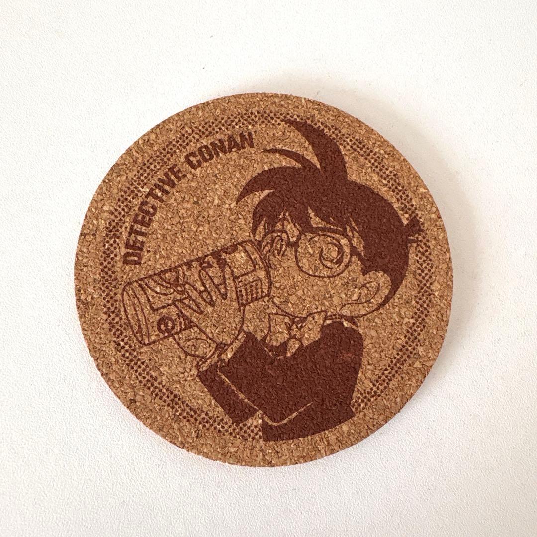 Round cork coaster showing the Detective Conan character drinking from a bottle.