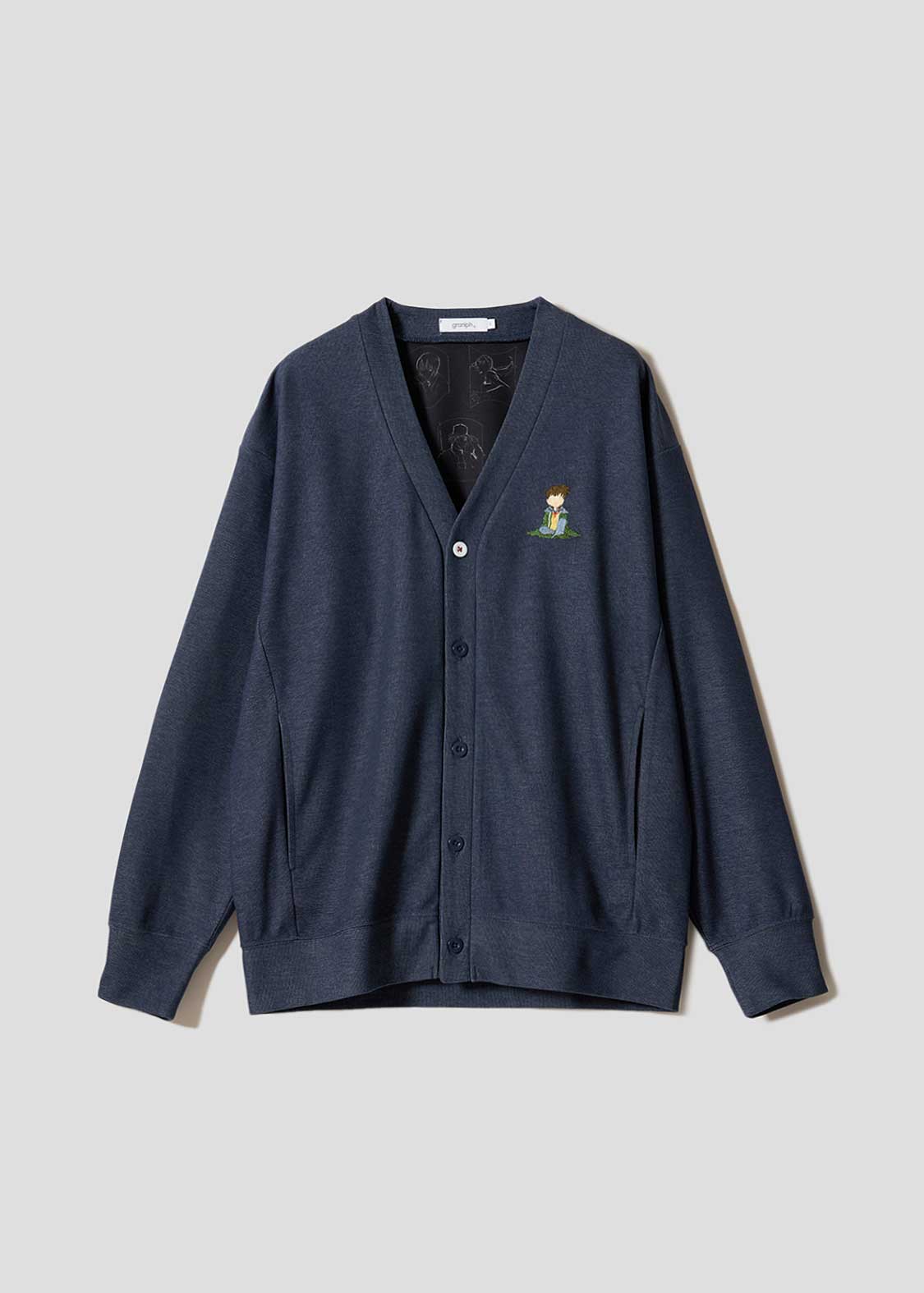 Front view of a navy double-face cardigan laid flat, showing buttons and a small embroidered character on the chest.