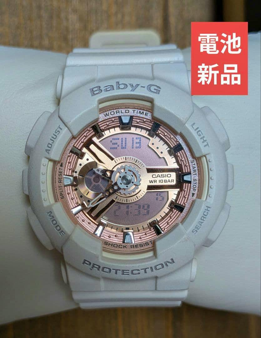 White Casio Baby-G BA-110 watch with a rose-gold dial displayed on a pillow.