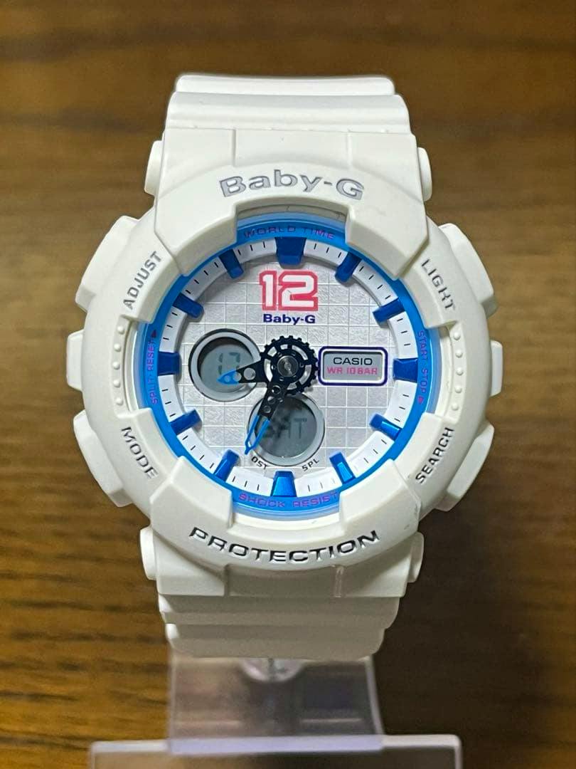 Front view of the white CASIO Baby-G BA-120 ladies' quartz watch on a clear display stand, showing the dial and strap.