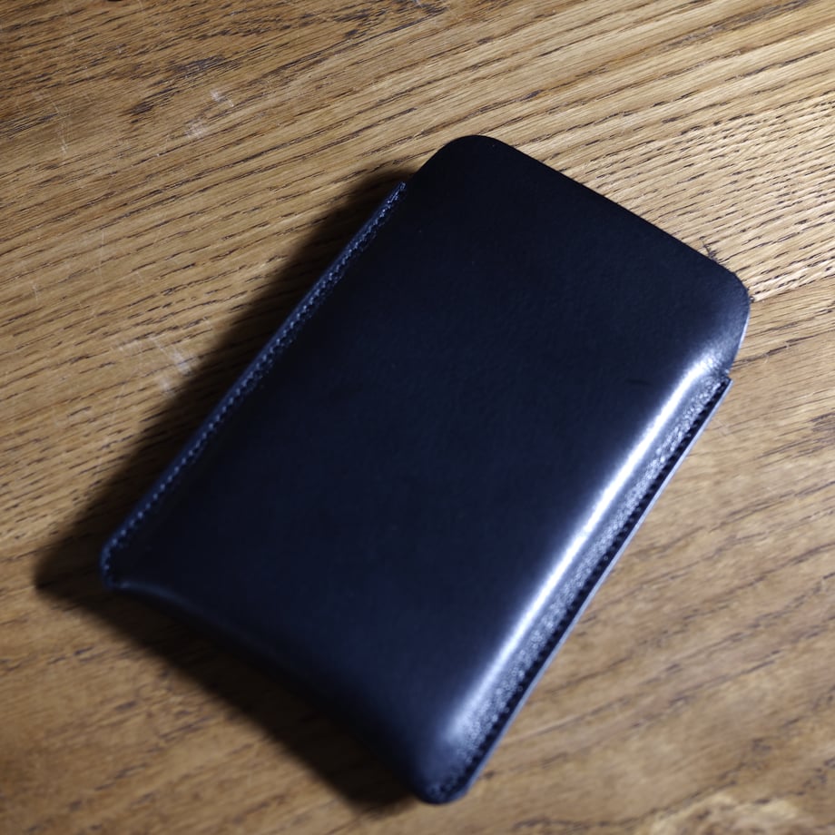 Black cow leather case for the Casio Premium Calculator S100NB displayed on a wooden surface.