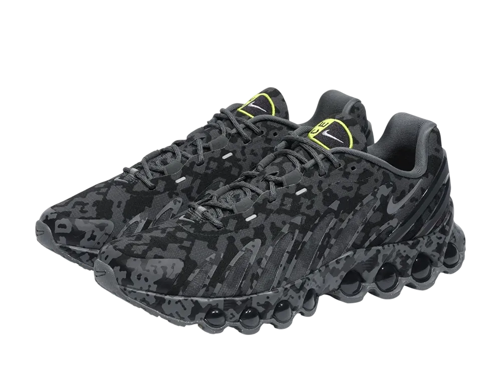 Pair of Cav Empt × Nike Air Max DN8 SP dark grey sports shoes shown in a three-quarter view on a black background.