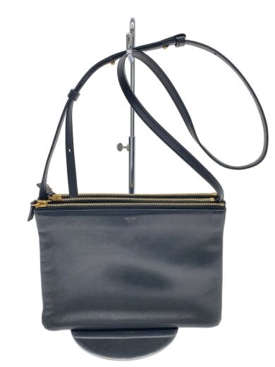 Front view of the CELINE black leather shoulder bag with zipper and adjustable strap displayed on a stand.