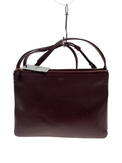 Front view of a burgundy Celine cow leather shoulder bag hanging from a hook.