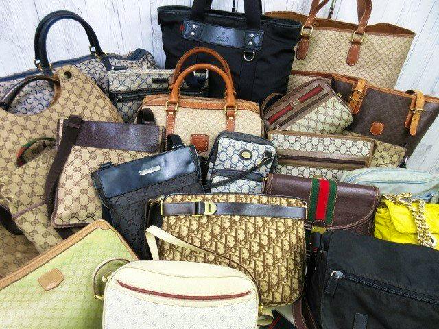 Multiple assorted canvas and leather bags and purses arranged together as a lot.