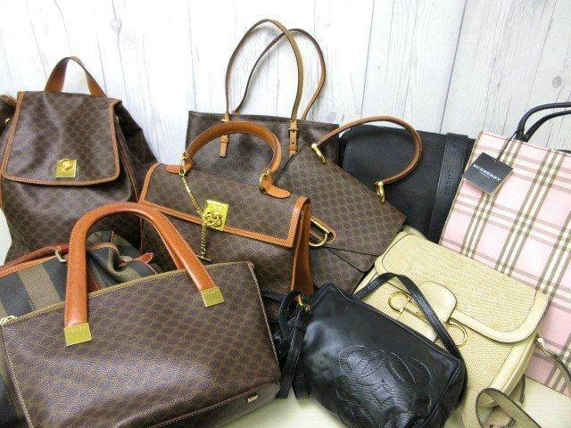 Multiple handbags and shoulder bags arranged together, including several brown patterned, black, and beige bags.