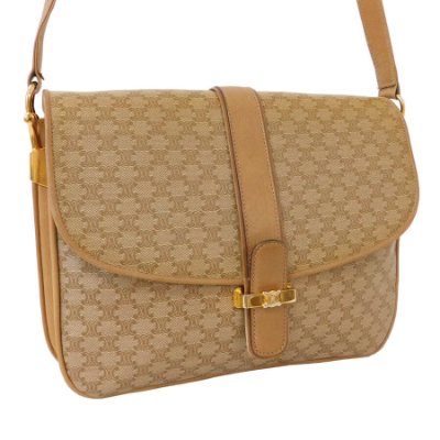 Front view of a beige Celine shoulder bag with macadam monogram pattern, flap closure, and leather strap.