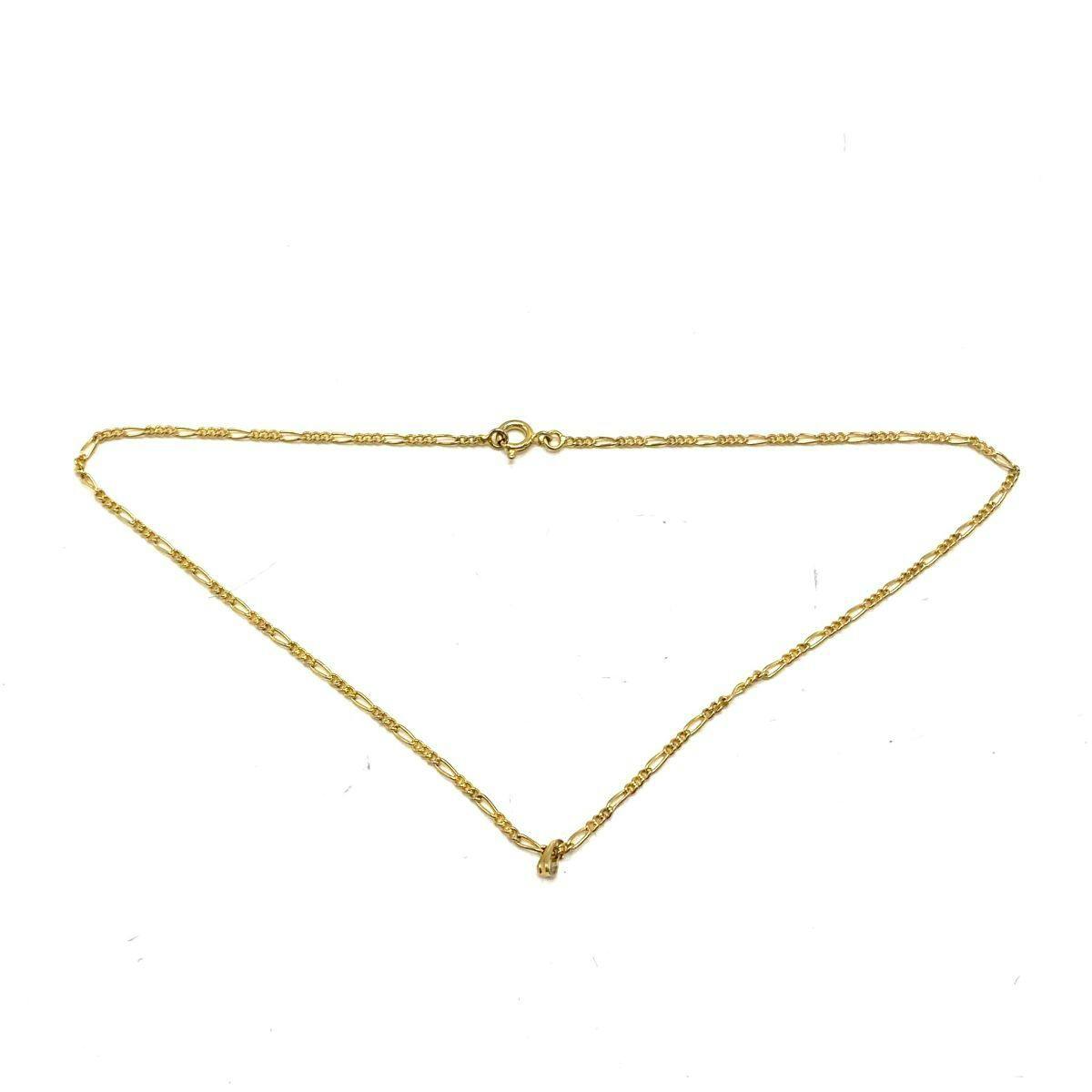 Gold-colored chain necklace laid flat on a white background, showing the clasp and small pendant.
