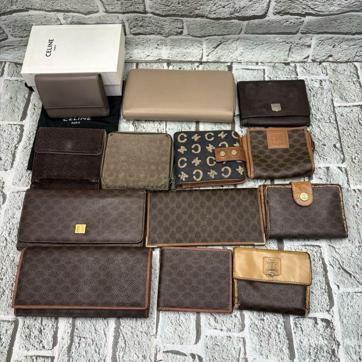 Multiple CELINE wallets and small leather accessories arranged with a CELINE box and dust bag on a textured surface.